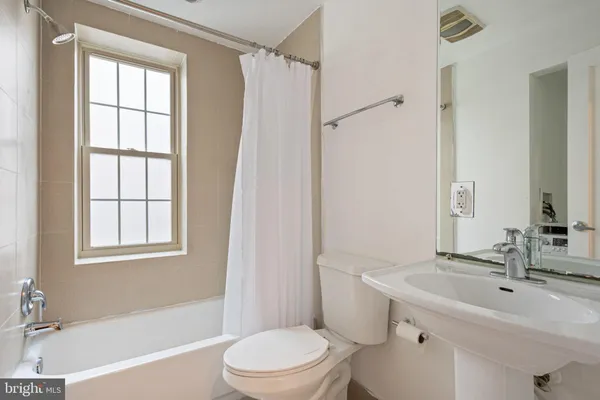 a bathroom with a toilet bathtub window and shower