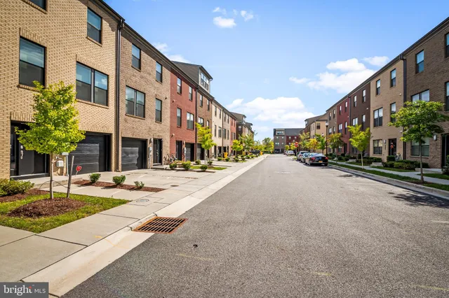a view of a street with a building and car parked in front of it