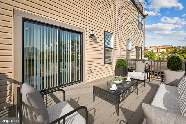 a view of a patio with a dining table and chairs with two plants