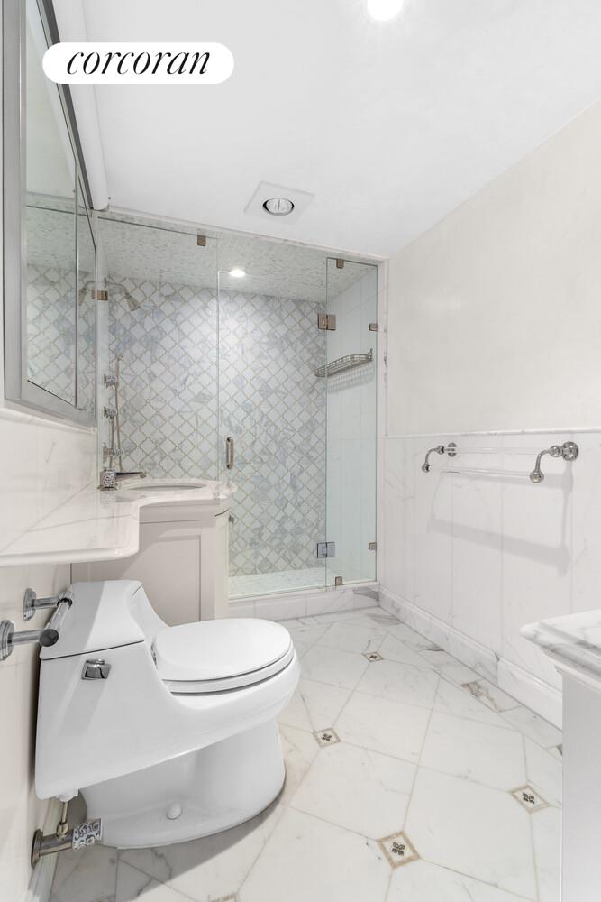 27 East 65th Street, Unit 14CD Manhattan, NY 10065 - Photo 15 of 16 a white toilet sitting next to a bathroom sink and shower