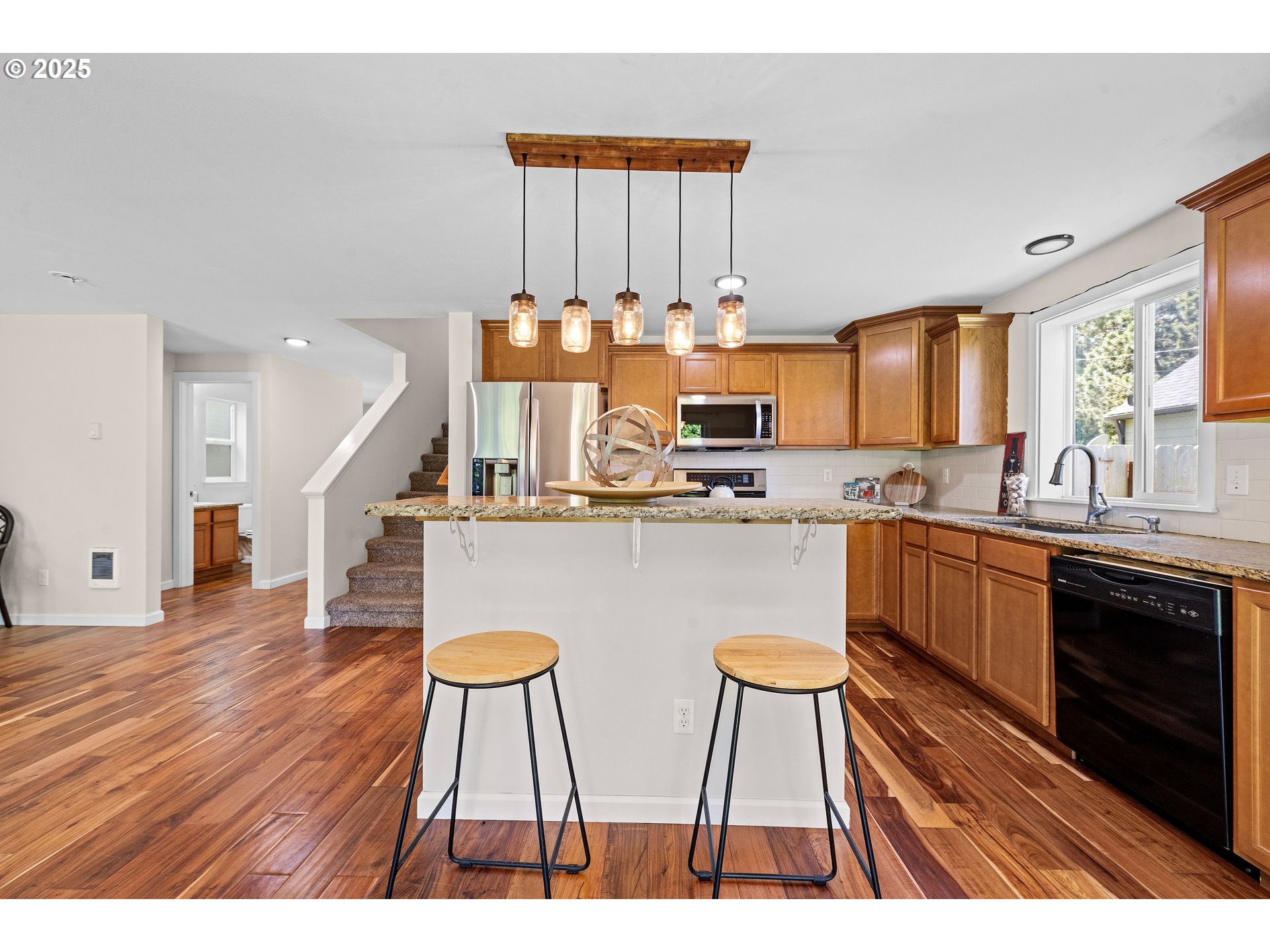1225 3rd Avenue Hammond, OR 97121 - Photo 13 of 47 a open kitchen with stainless steel appliances granite countertop a stove a sink dishwasher and a microwave with wooden floor