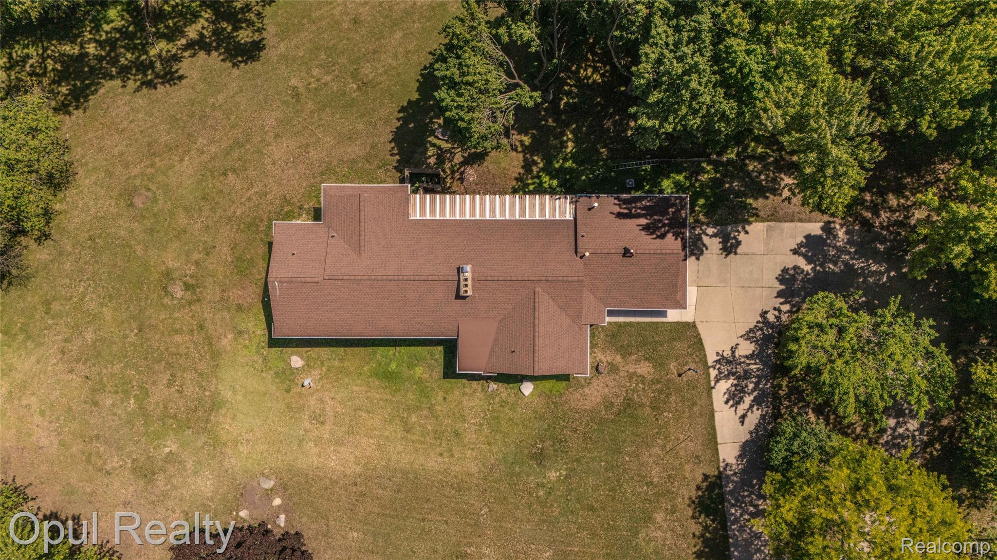 6455 Norham Road Bloomfield Hills, MI 48301 - Photo 89 of 93 Property featuring a brown shingled roof, a paved driveway, and expansive grassy areas