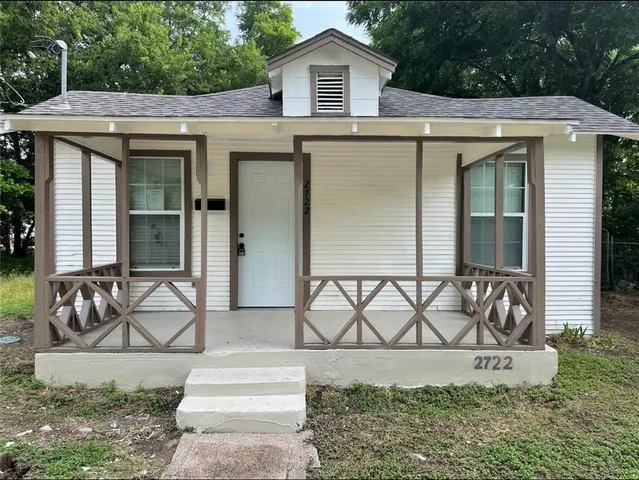 a view of a house with a yard and patio