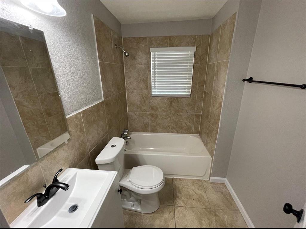 2722 Hector Street Dallas, TX 75210 - Photo 9 of 10 a white toilet sitting next to a bathroom sink and tub