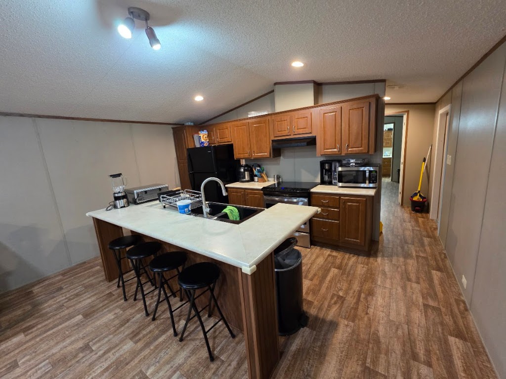 1100 Rustler Pass Kyle, TX 78640 - Photo 6 of 14 a kitchen with a table chairs refrigerator and cabinets