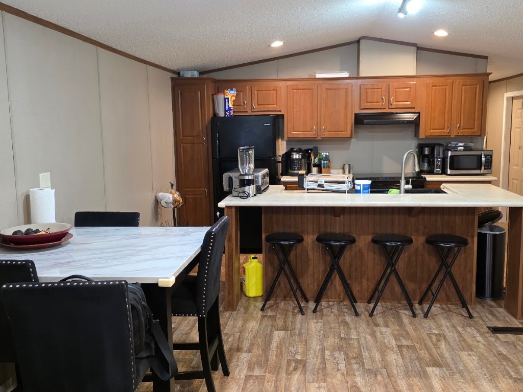 1100 Rustler Pass Kyle, TX 78640 - Photo 7 of 14 a kitchen with a table chairs refrigerator and cabinets