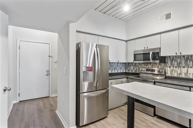 a kitchen with stainless steel appliances a stove a sink and a refrigerator