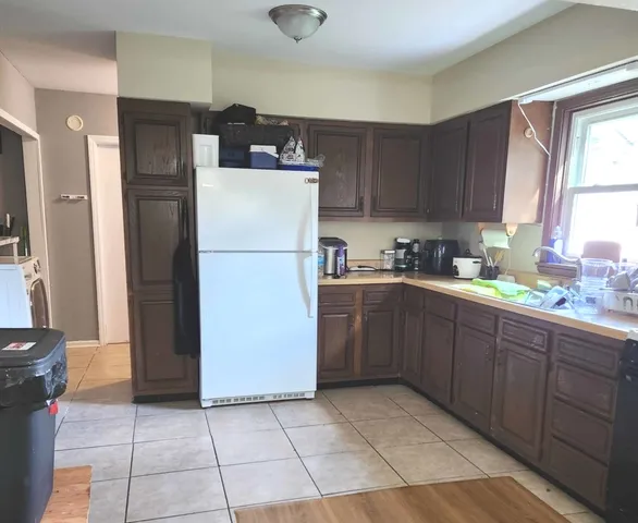 a kitchen with a refrigerator a stove top oven and cabinets