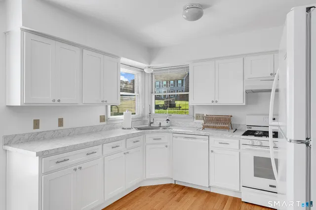a kitchen with white cabinets sink and white appliances