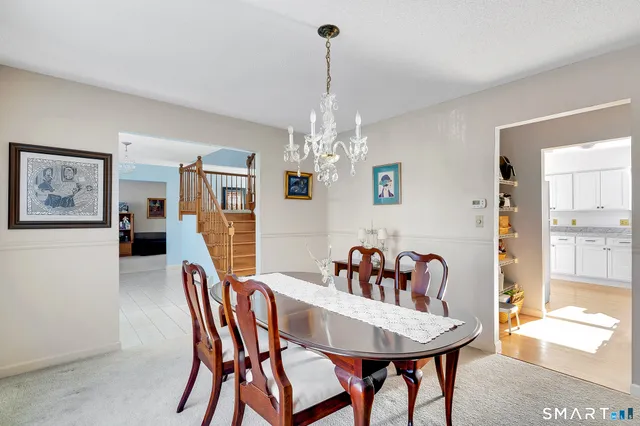 a dining room with furniture a chandelier and window