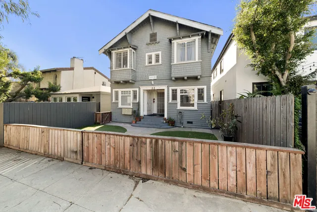 a front view of a house with wooden fence