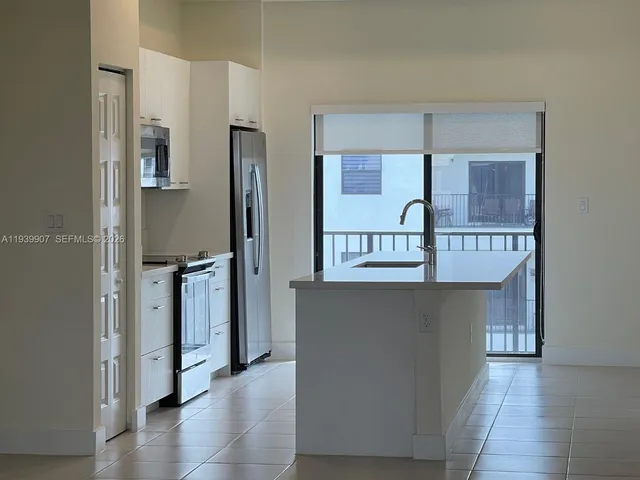 a kitchen with stainless steel appliances granite countertop a refrigerator and a stove