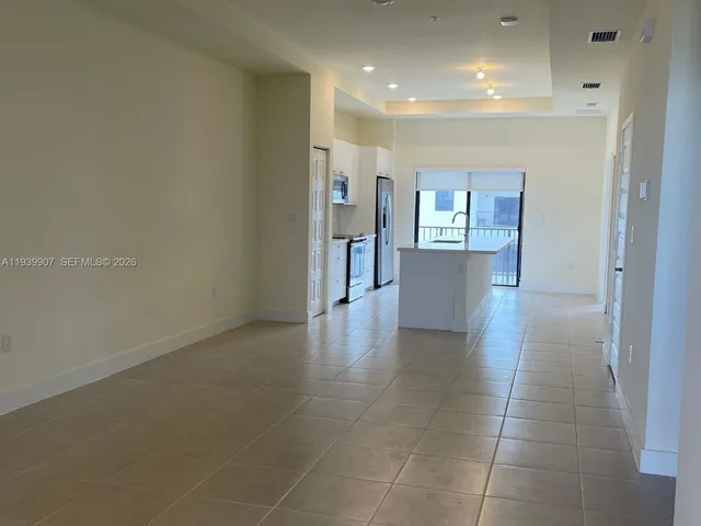 a view of a hallway with wooden floor and a living room