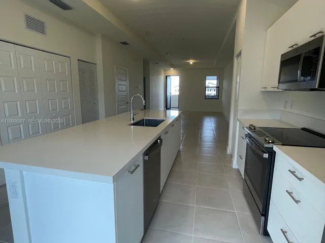 a kitchen with stainless steel appliances a sink stove and cabinets