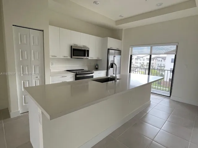 a kitchen with stainless steel appliances granite countertop a sink a stove and a refrigerator