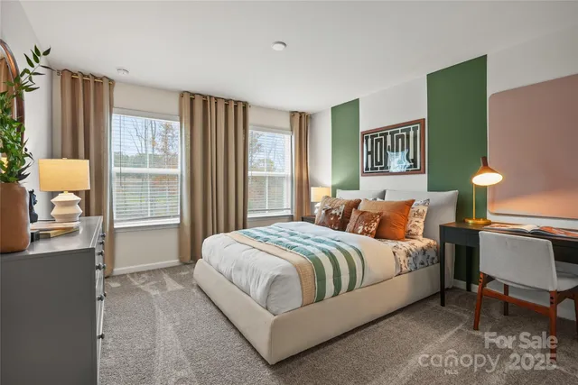 a bedroom with a bed lamp and a large window