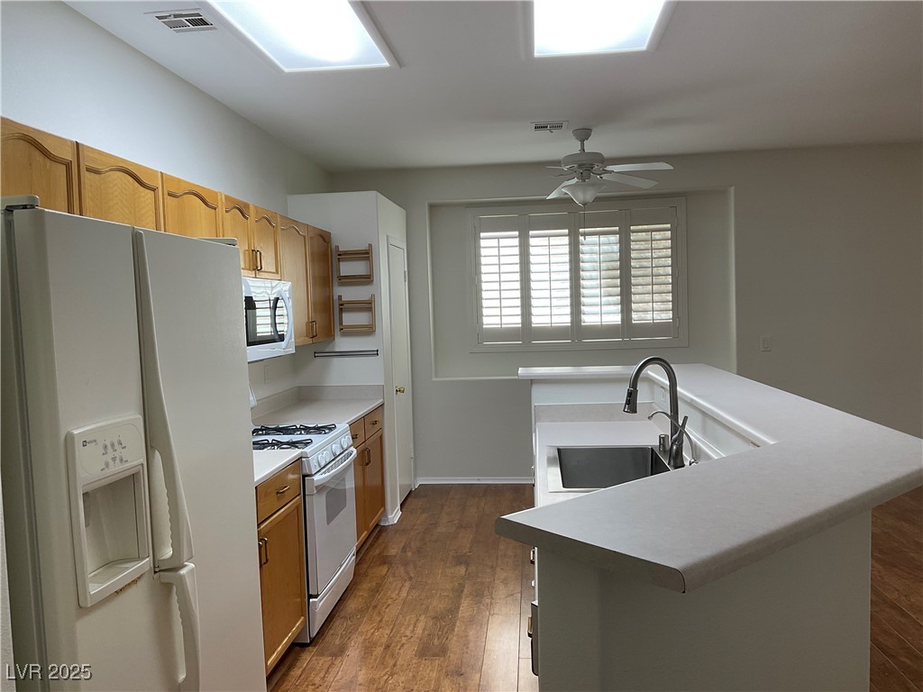 7620 Donald Nelson Avenue Las Vegas, NV 89131 - Photo 10 of 34 Kitchen featuring white appliances, a sink, ceiling fan, dark wood-style floors, and light countertops