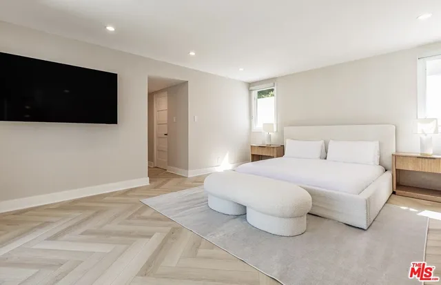 a bedroom with a bed and a flat screen tv