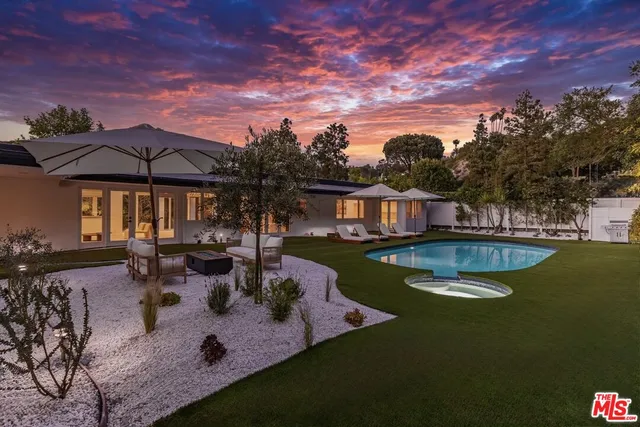 a view of a house with swimming pool and sitting area