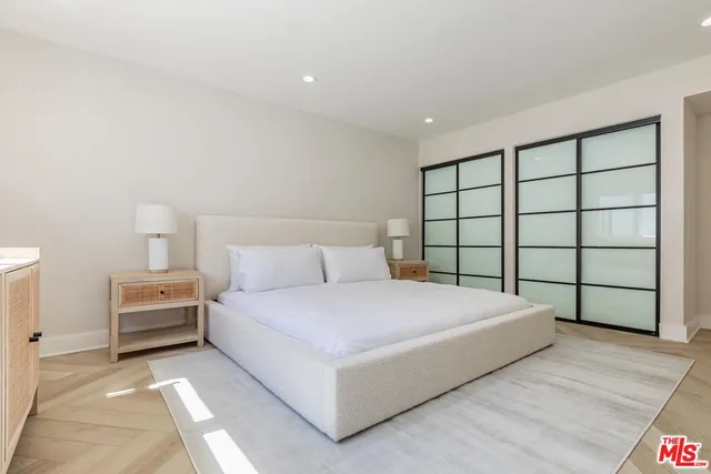 a large bedroom with a bed and a large window