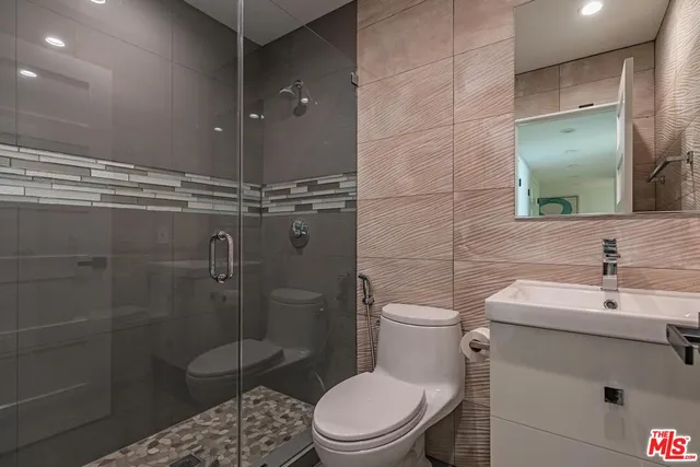 a bathroom with a toilet a sink and shower