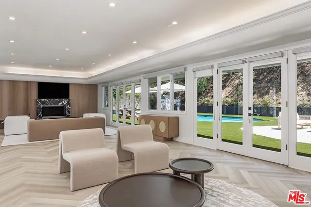 a living room with fireplace furniture and a large window