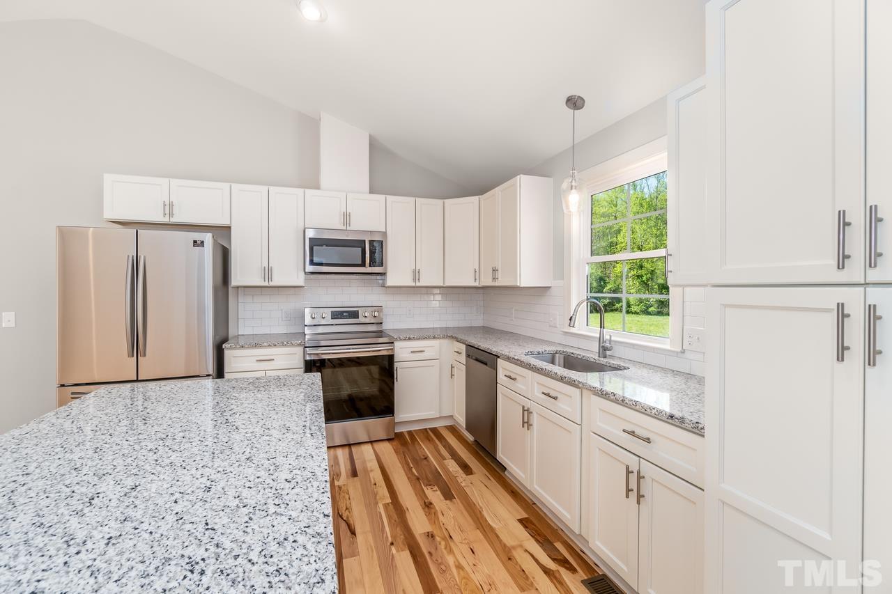 9503 Meredith Drive Rougemont, NC 27572 - Photo 8 of 15 a kitchen with stainless steel appliances granite countertop a stove a sink and a refrigerator