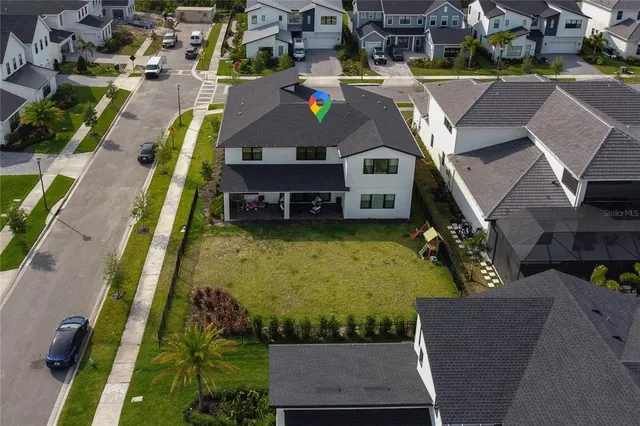 an aerial view of a house with a garden and lake view