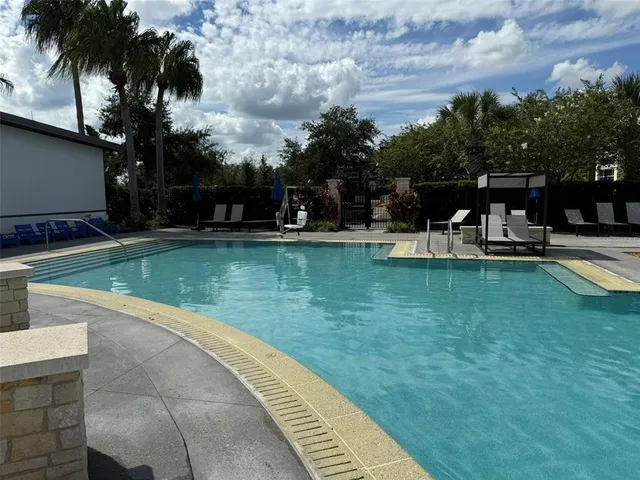 a view of a brick house with large windows and potted plants