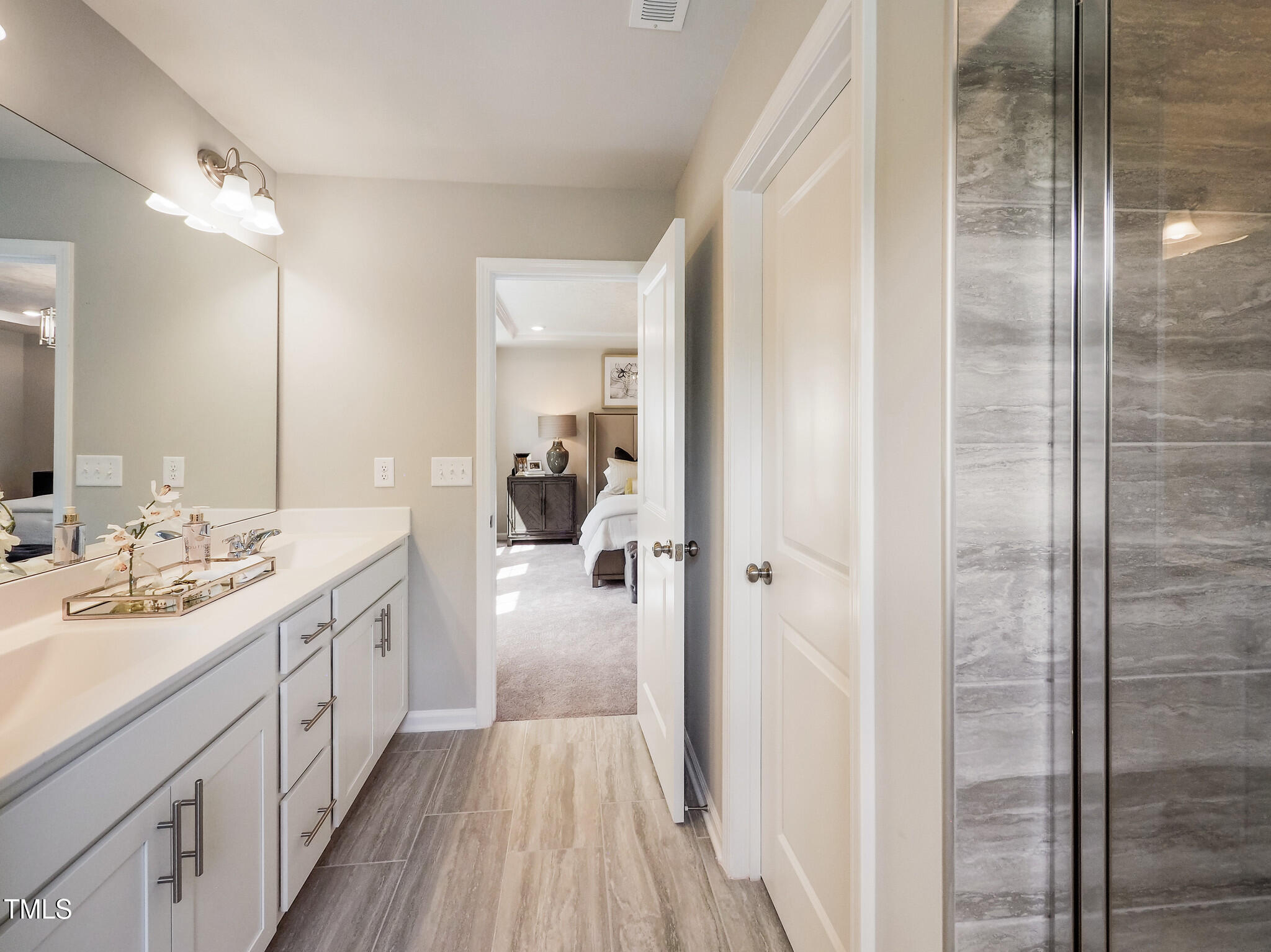 1124 Barred Owl Trail Wake Forest, NC 27587 - Photo 15 of 16 a spacious bathroom with a double vanity sink a mirror and shower