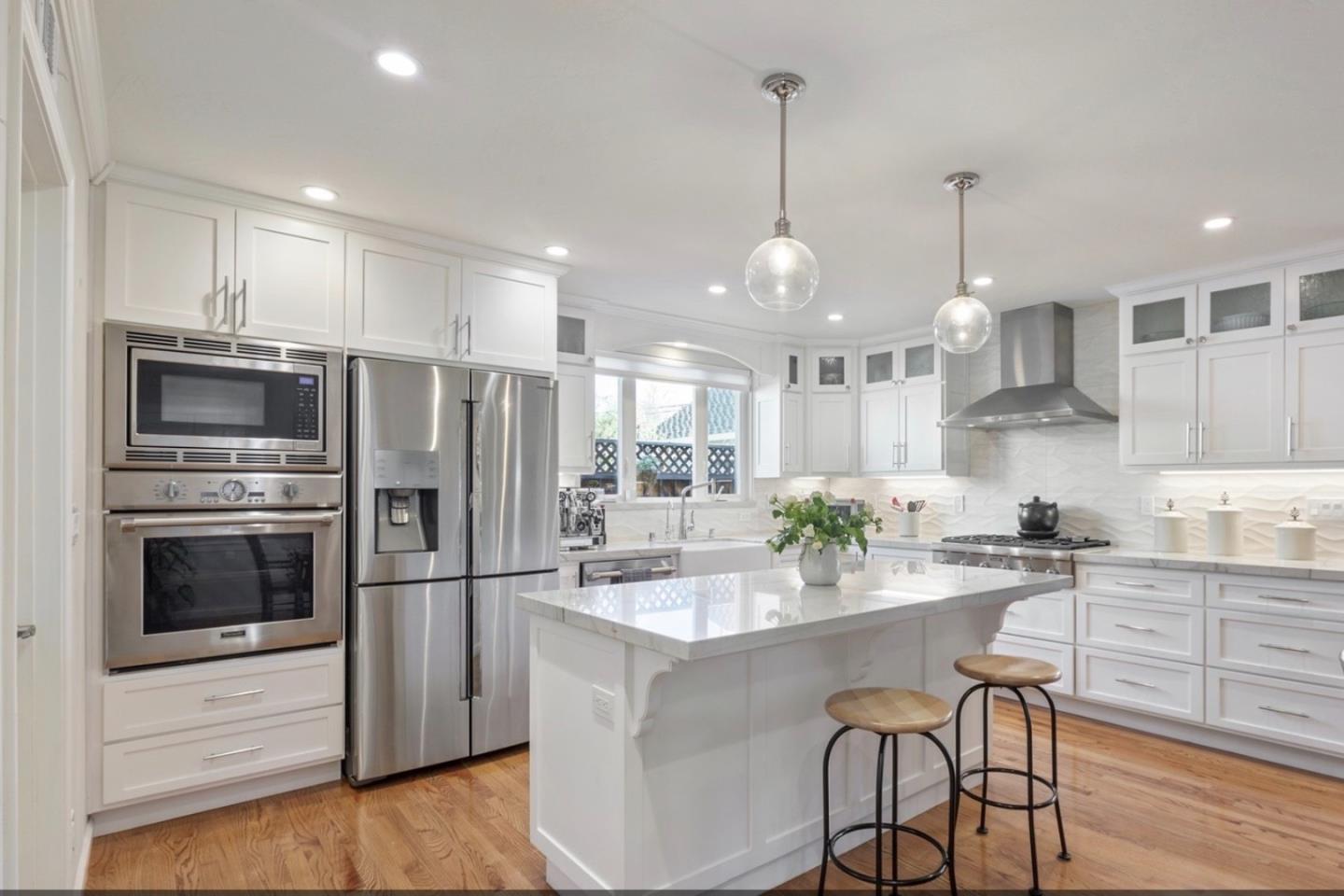 1470 Ridgeley Drive Campbell, CA 95008 - Photo 4 of 12 a kitchen with stainless steel appliances kitchen island granite countertop a kitchen island a stove a refrigerator and a wooden cabinets