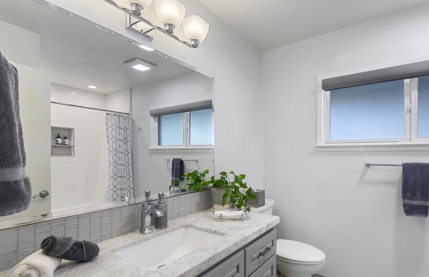 1470 Ridgeley Drive Campbell, CA 95008 - Photo 9 of 12 a bathroom with a granite countertop sink a toilet and mirror