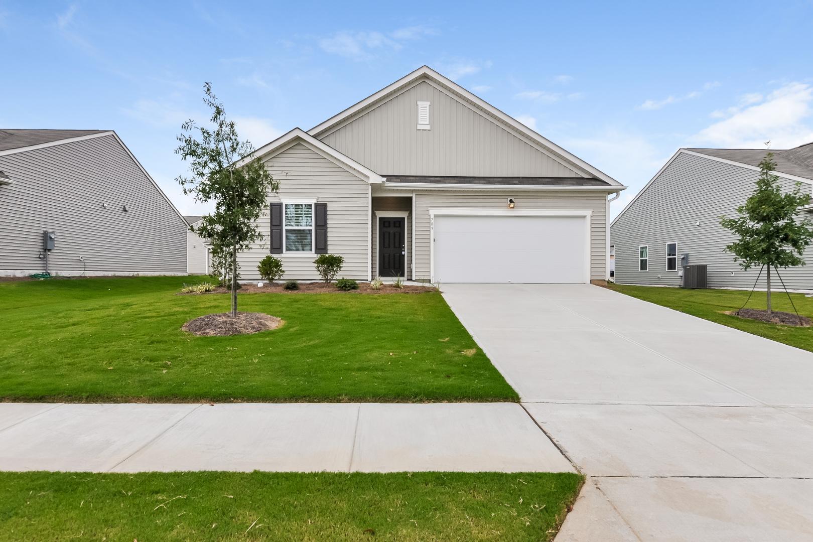 709 Kenyon Spring Drive Zebulon, NC 27597 - Photo 1 of 18 a house with garden in front of it