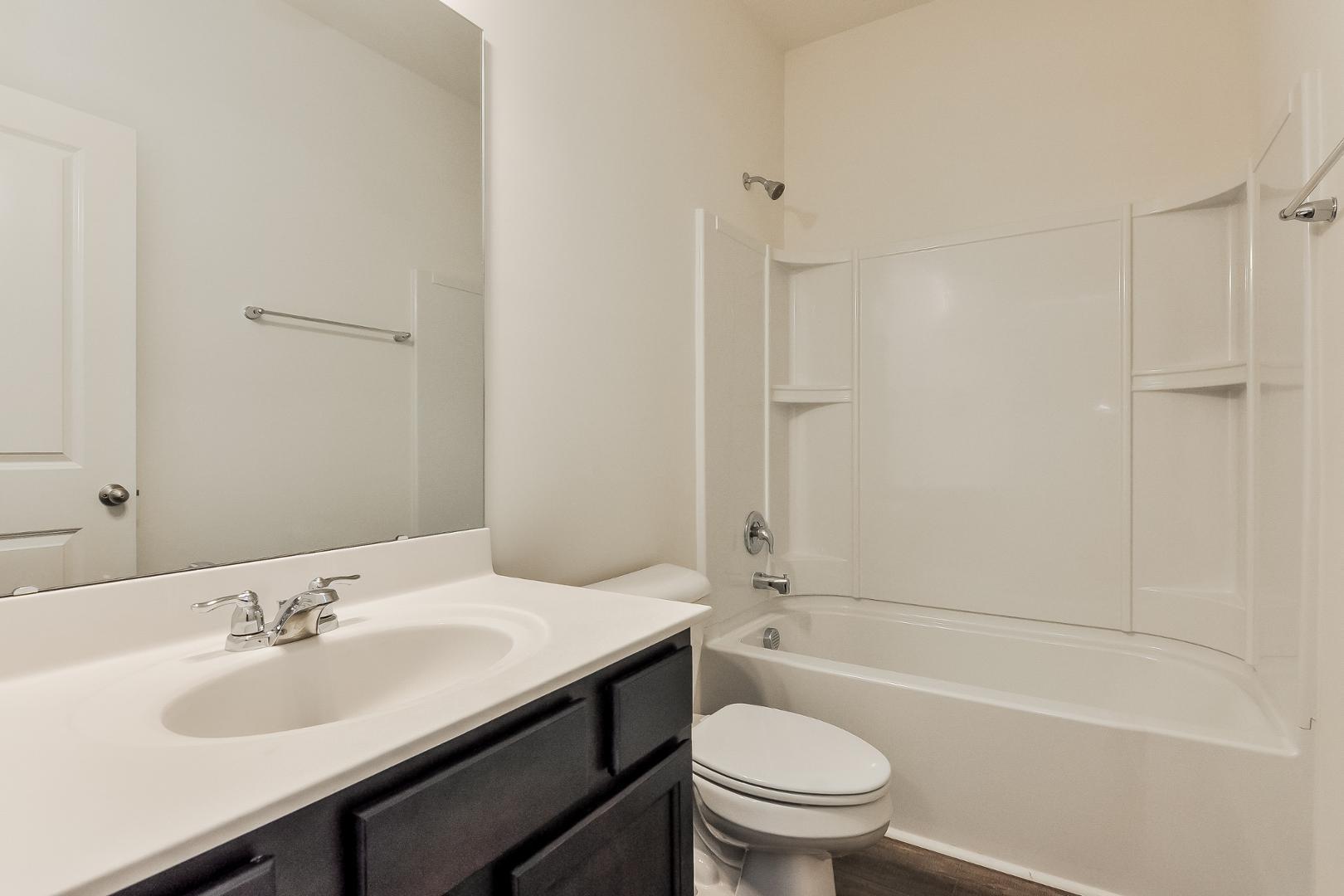709 Kenyon Spring Drive Zebulon, NC 27597 - Photo 12 of 18 a bathroom with a sink a toilet and shower