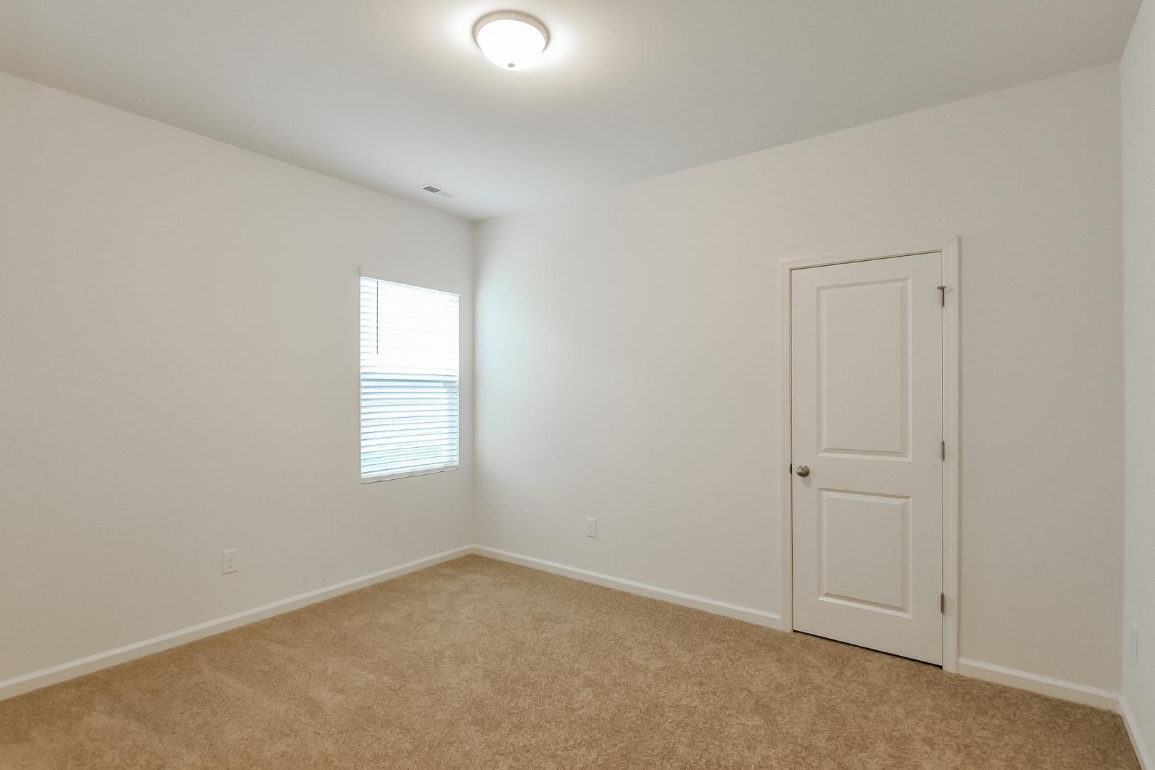 709 Kenyon Spring Drive Zebulon, NC 27597 - Photo 13 of 18 an empty room with windows and closet
