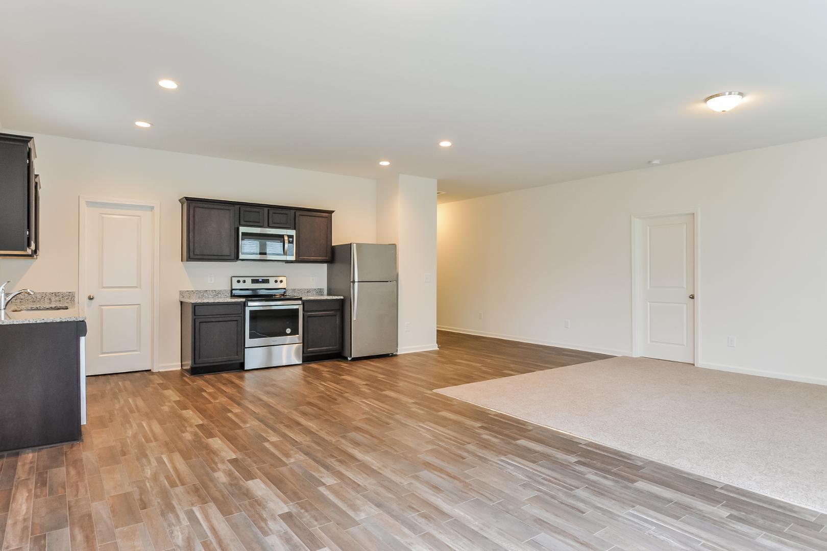 709 Kenyon Spring Drive Zebulon, NC 27597 - Photo 5 of 18 a kitchen with stainless steel appliances a refrigerator and a stove top oven