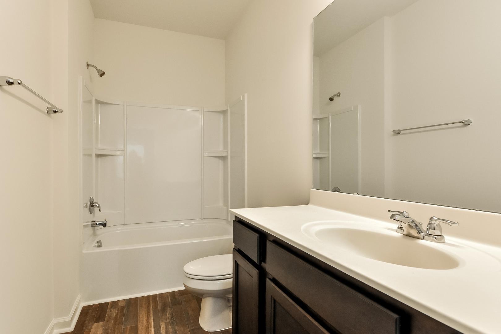 709 Kenyon Spring Drive Zebulon, NC 27597 - Photo 9 of 18 a bathroom with a sink a toilet and shower