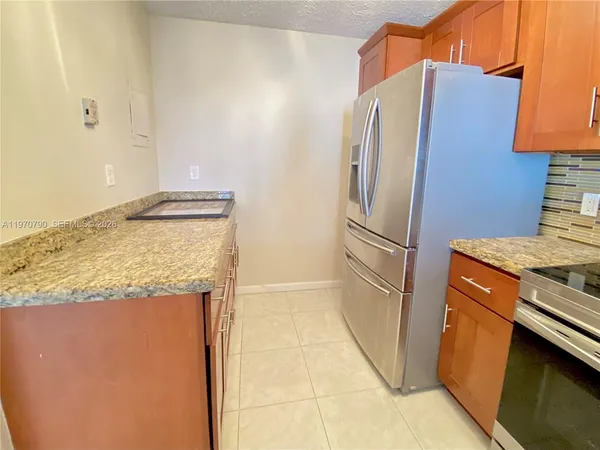 a kitchen with stainless steel appliances granite countertop a refrigerator and a stove