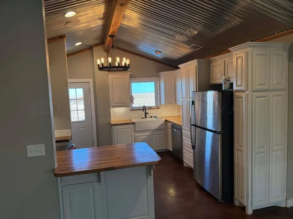 a kitchen with refrigerator a sink and chairs