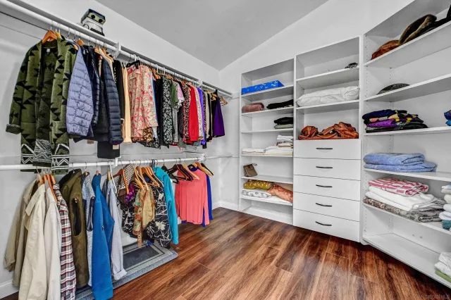 a view of walk in closet with clothes and shoes