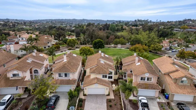 an aerial view of residential houses with outdoor space and ocean view