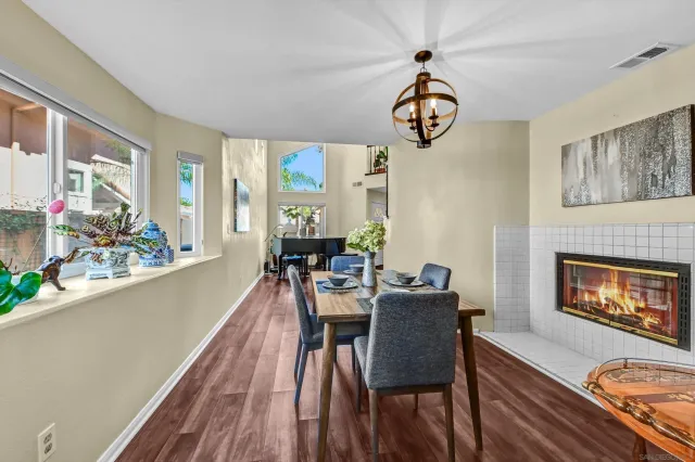 a dining room with furniture a fireplace a rug a fireplace and a chandelier
