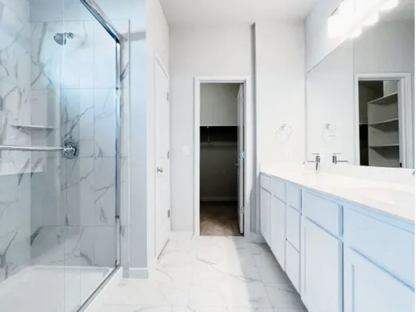 a bathroom with a double vanity sink and shower