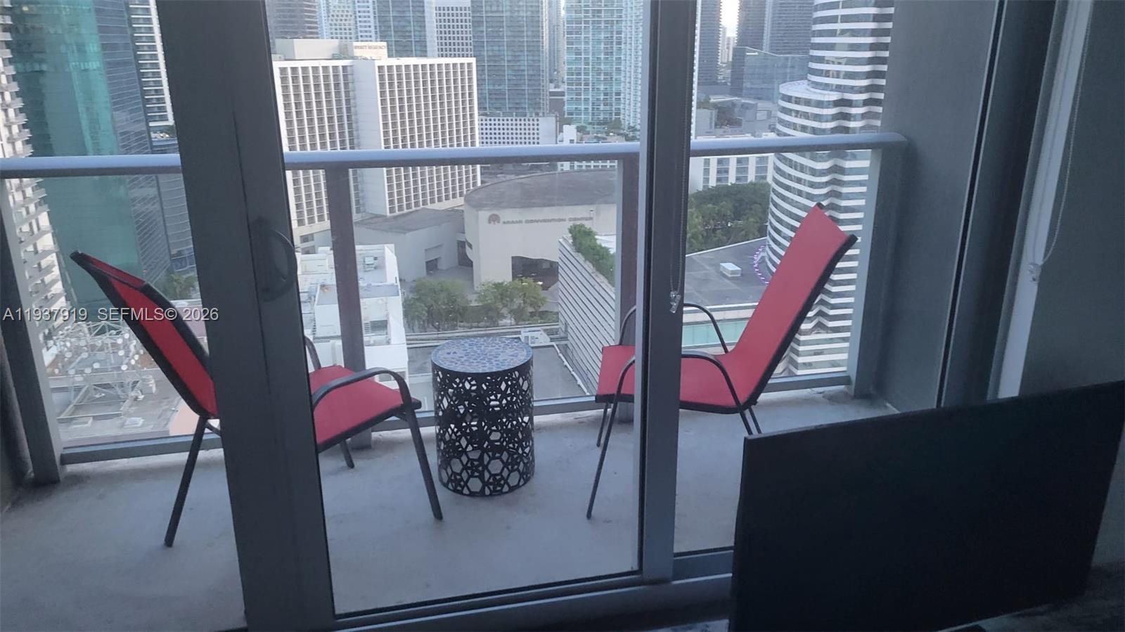 151 Southeast 1st Street, Unit 2507 Miami, FL 33131 - Photo 3 of 34 a view of a balcony with chairs and wooden floor
