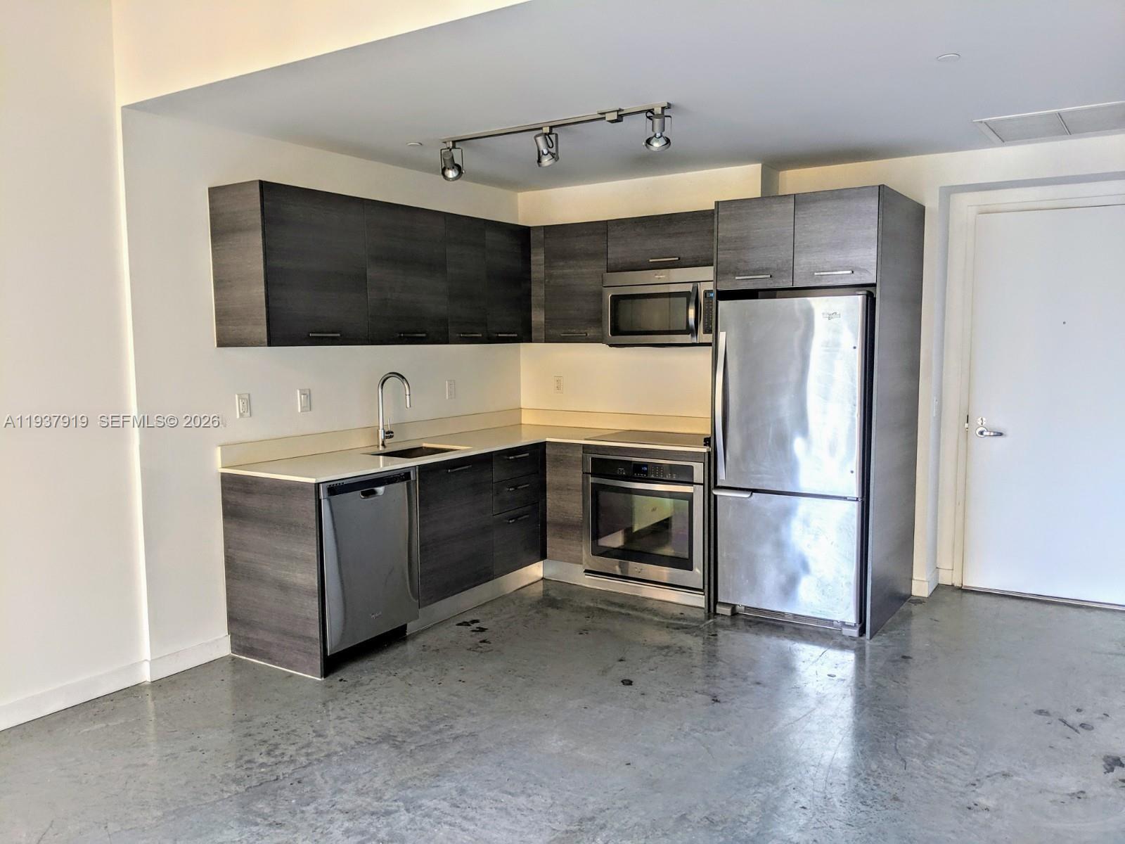 151 Southeast 1st Street, Unit 2507 Miami, FL 33131 - Photo 31 of 34 a kitchen with stainless steel appliances a refrigerator and a stove top oven