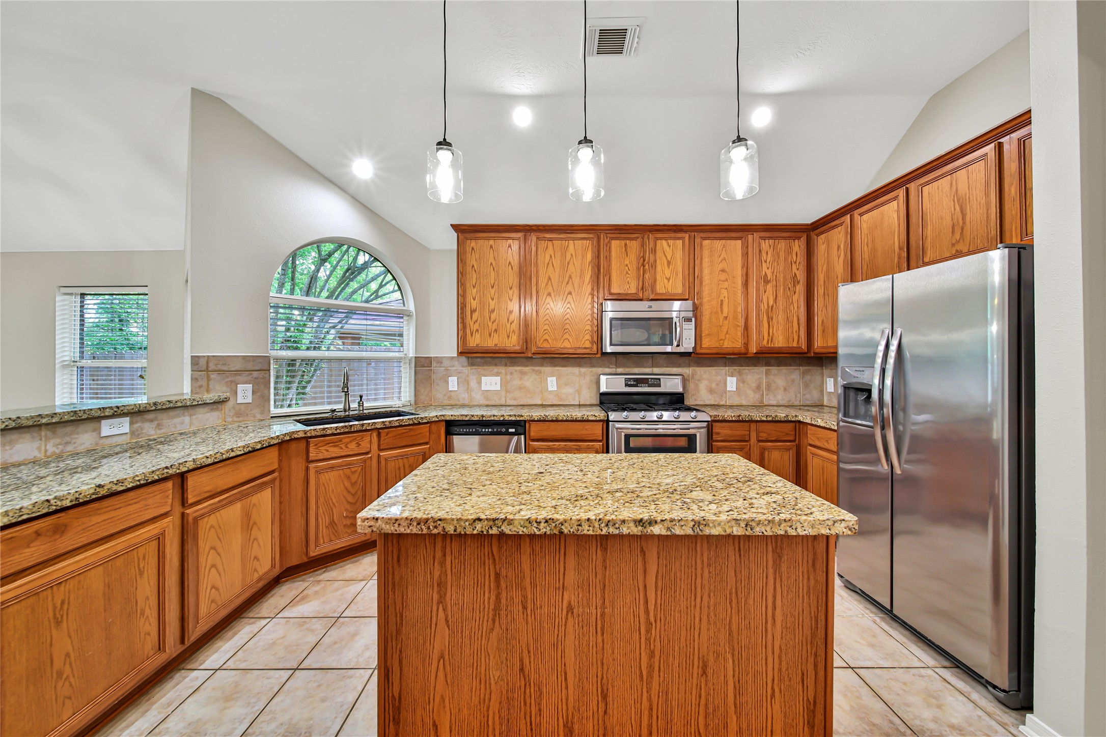 14526 Red Tailed Hawk Lane Houston, TX 77044 - Photo 9 of 40 a kitchen with stainless steel appliances granite countertop a sink a stove a refrigerator cabinets and a kitchen island