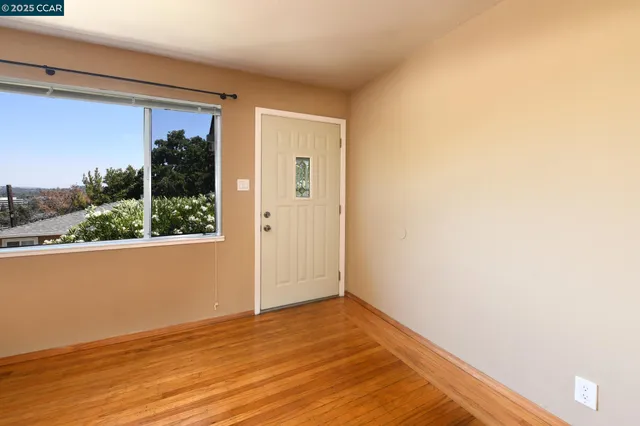 a view of a hallway with wooden floor and a window