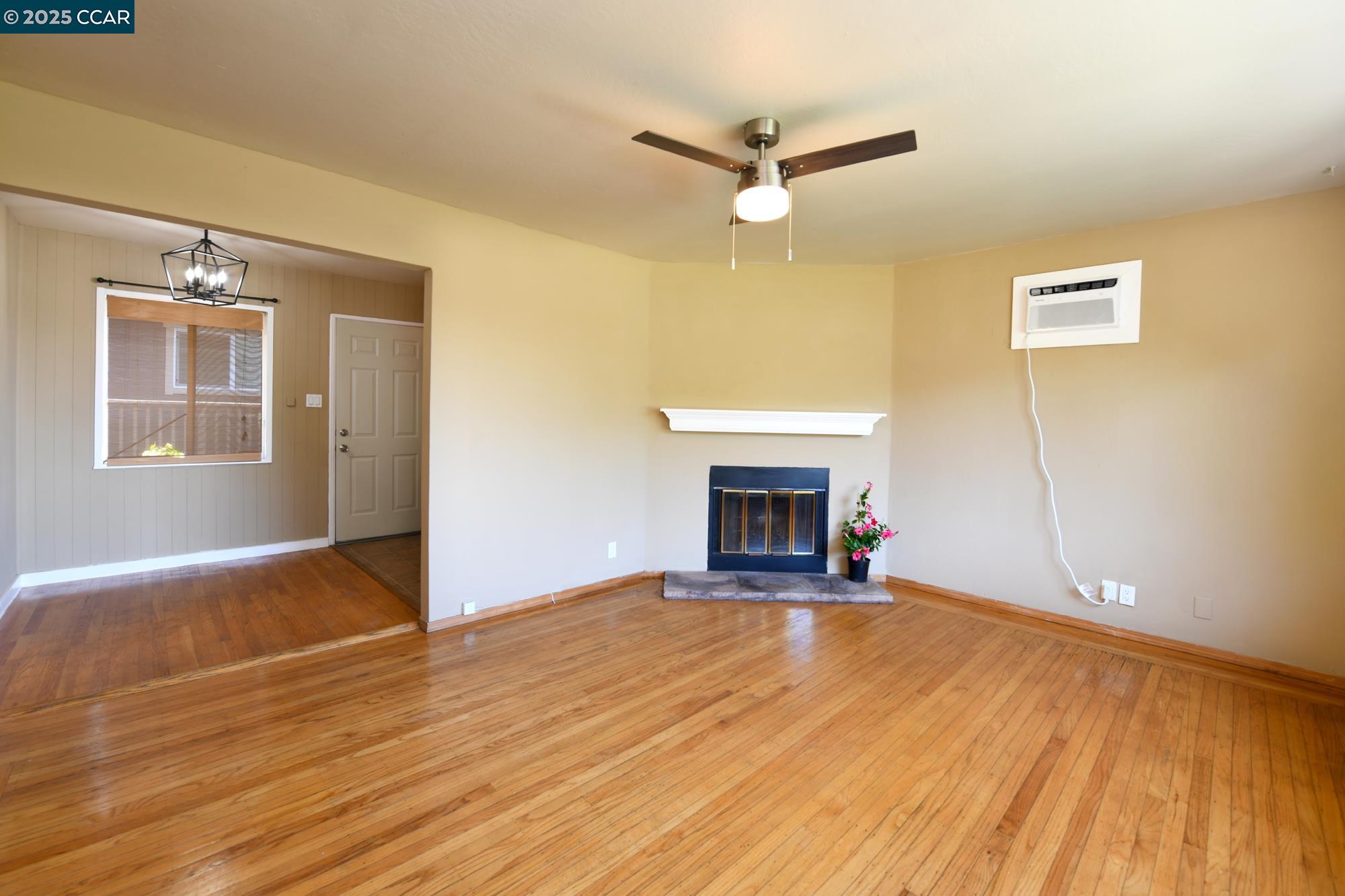 1672 Terrace Road Walnut Creek, CA 94597 - Photo 4 of 38 an empty room with wooden floor fireplace and windows
