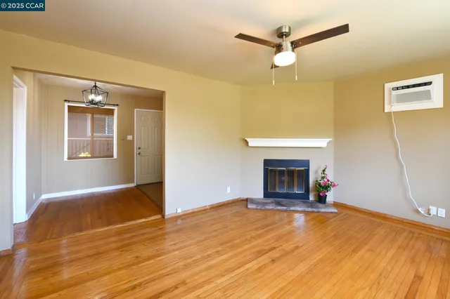 a view of empty room with wooden floor and fireplace