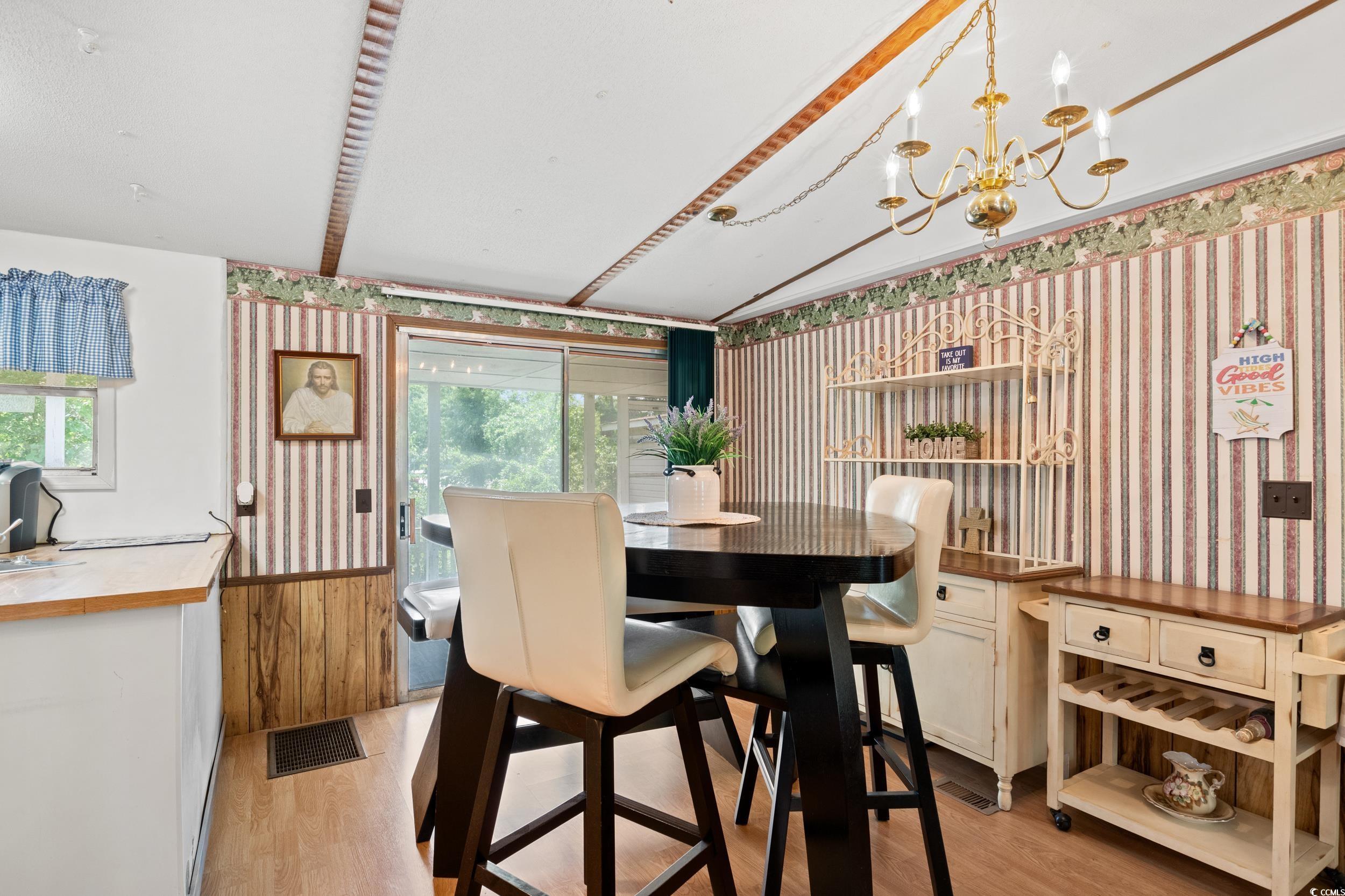 563 Plum Court Myrtle Beach, SC 29579 - Photo 12 of 34 Dining room featuring wallpapered walls, light wood finished floors, plenty of natural light, a chandelier, and beam ceiling